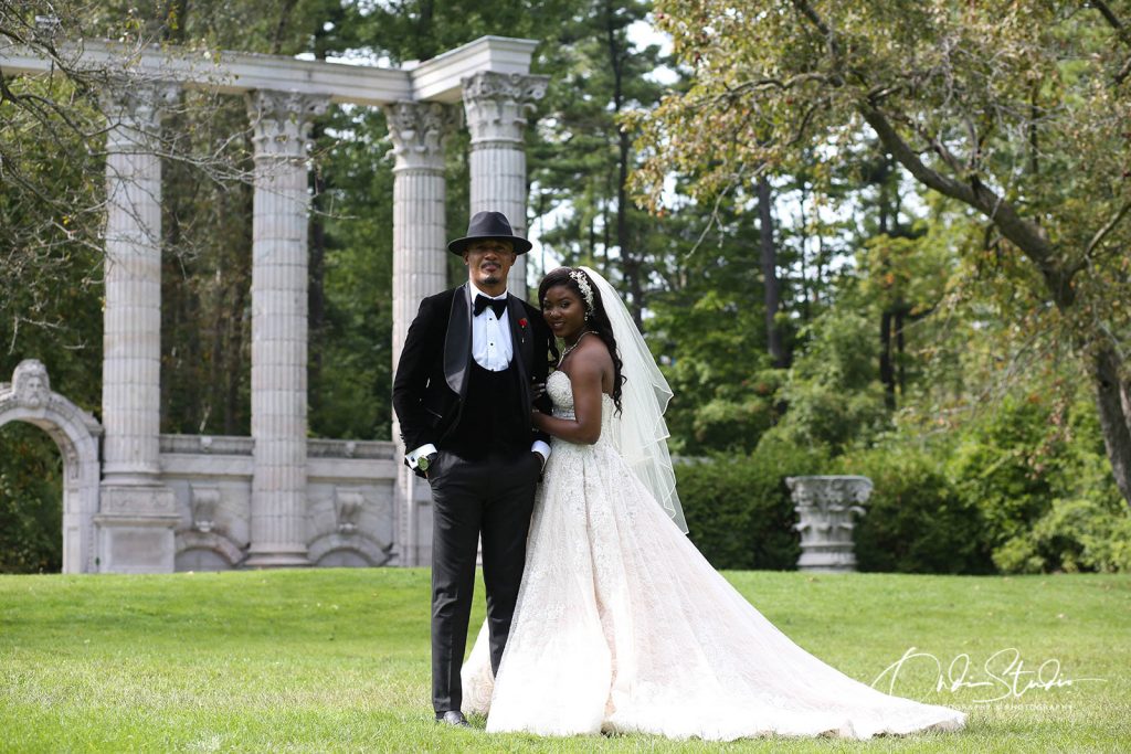 Wedding Photography Ideas with Ondi Studio: Capturing Your Special Moments 4 Therese and Vally’s wedding, captured by ONDI Studio, shows the couple standing in a picturesque outdoor setting. They are posed in front of grand stone columns, creating a majestic and timeless backdrop. Therese looks stunning in her lace wedding gown, and Vally is dressed in a classic black suit with a wide-brimmed hat, adding a unique and stylish touch to his look. The lush greenery surrounding the couple, combined with the ancient architectural elements, makes for a beautiful and elegant wedding portrait.