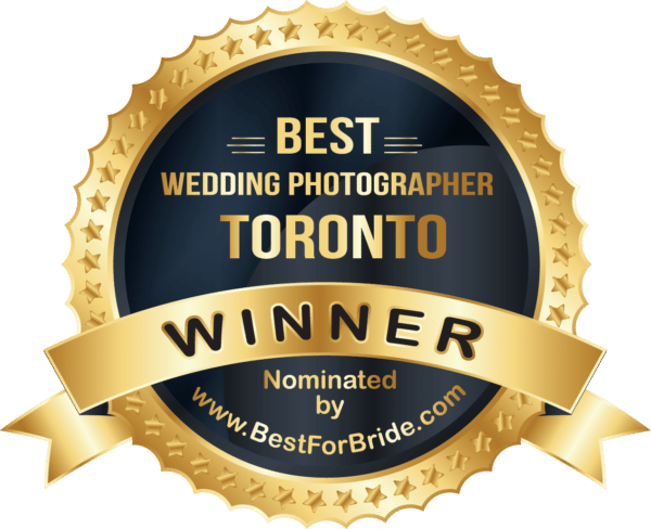 An emblem displaying 'BEST Wedding Photographer TORONTO WINNER' with a golden ribbon stating 'Nominated by www.BestForBride.com' set against a starry background.